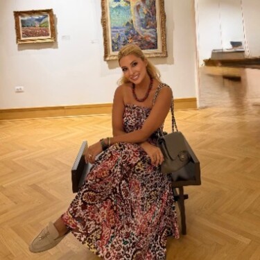 Iremsu Hersek seated in an art gallery